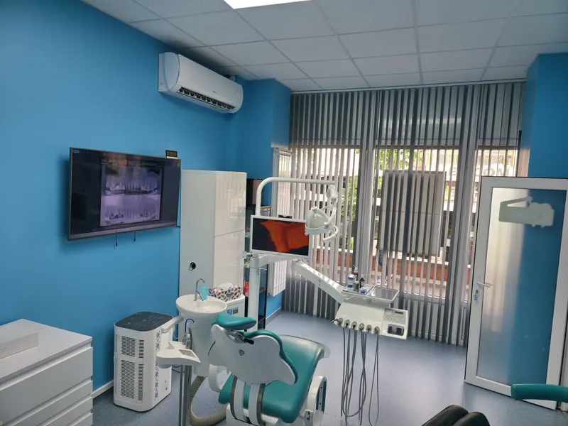 Cabinet luminos cu ferestre mari, jaluzele verticale, unit dentar și monitor pe perete