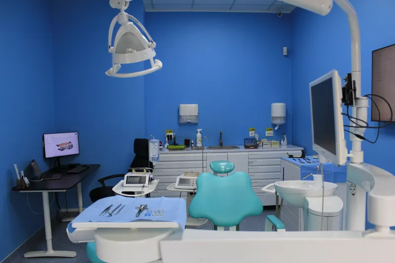 Unit dentar turcoaz pregătit pentru tratament, cu lampa deasupra