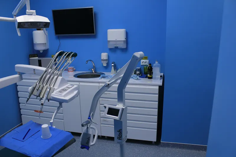 Unit dentar cu piesele de mână și tava pregătite, în cabinetul cu pereți albaștri