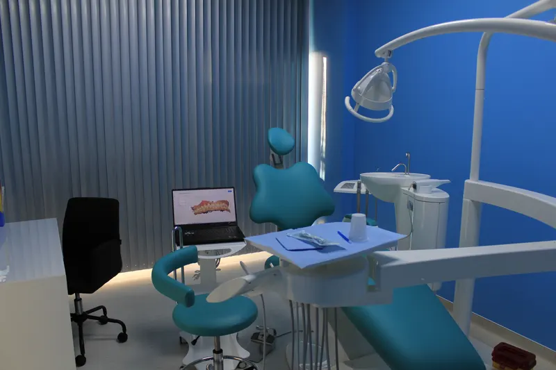 Unit dentar turcoaz pregătit, cu laptop și tavă de instrumente