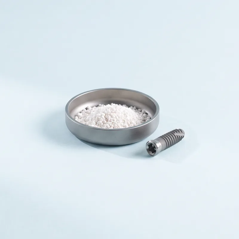 Granule de adiție osoasă într-un vas din titan, lângă un implant dentar