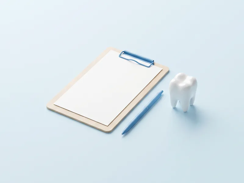 Plan de tratament pe un clipboard, cu un pix albastru și un model de molar